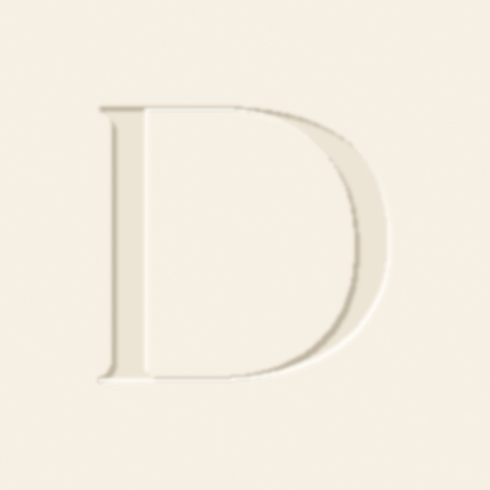 The Divine letter D, pressed into cream paper like a letterpress plate